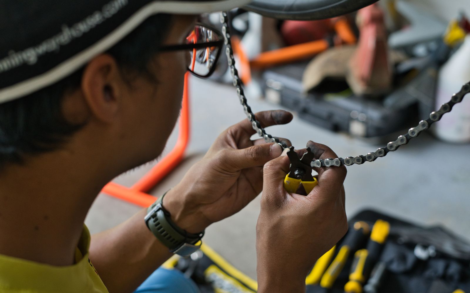 Fietsenmaker werkt aan de ketting van een fiets